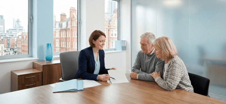 A professional solicitor at Gregory Abrams Davidson discussing a Lasting Power of Attorney document with a senior couple in a bright, modern office with a light blue and grey colour palette.